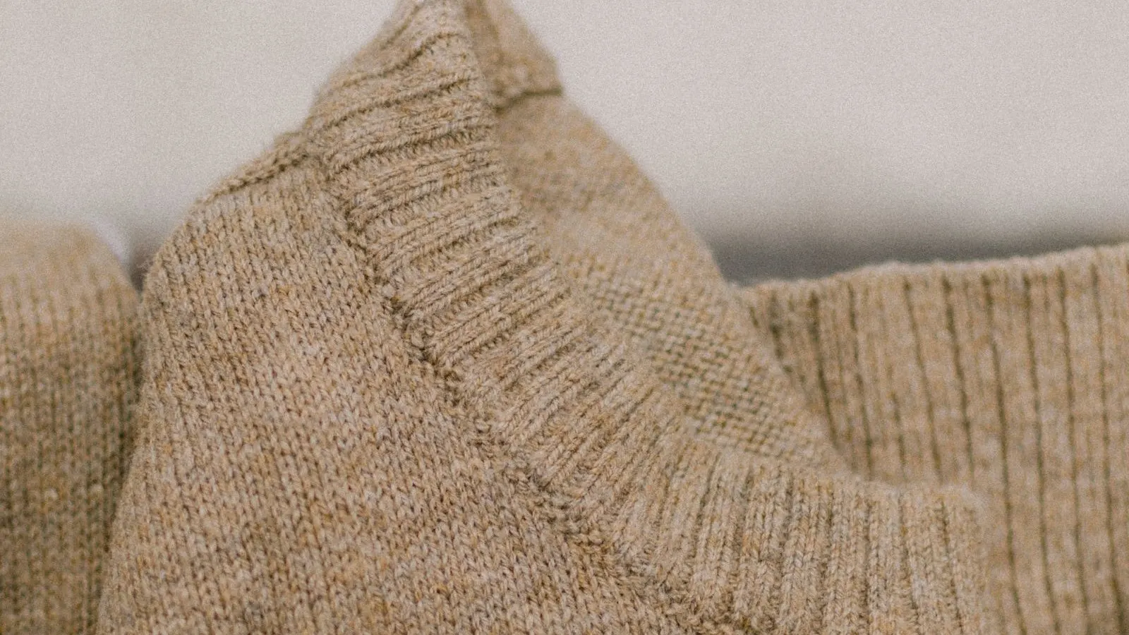 Close-up of a beige cashmere knit, representing static cling and winter knitwear care.