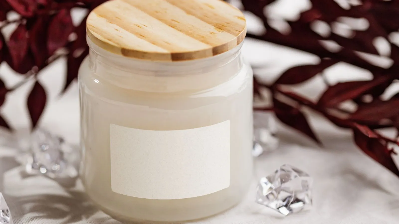 Candle jar with label, representing label wrinkling on glass jars.
