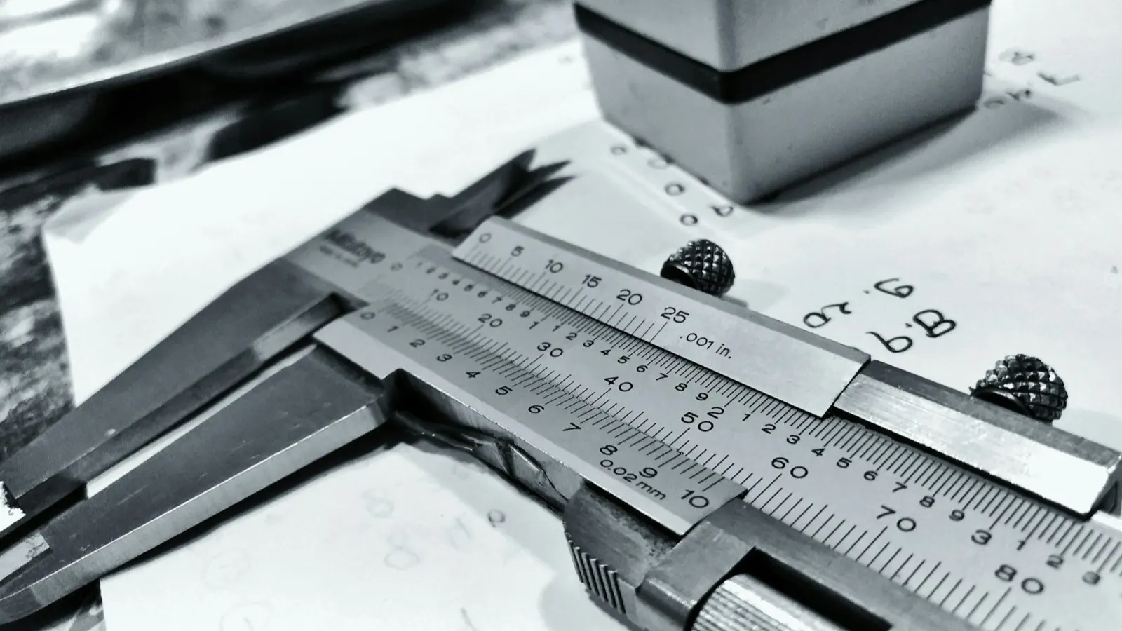 Calipers measuring a bottle closure, representing induction liner sizing.