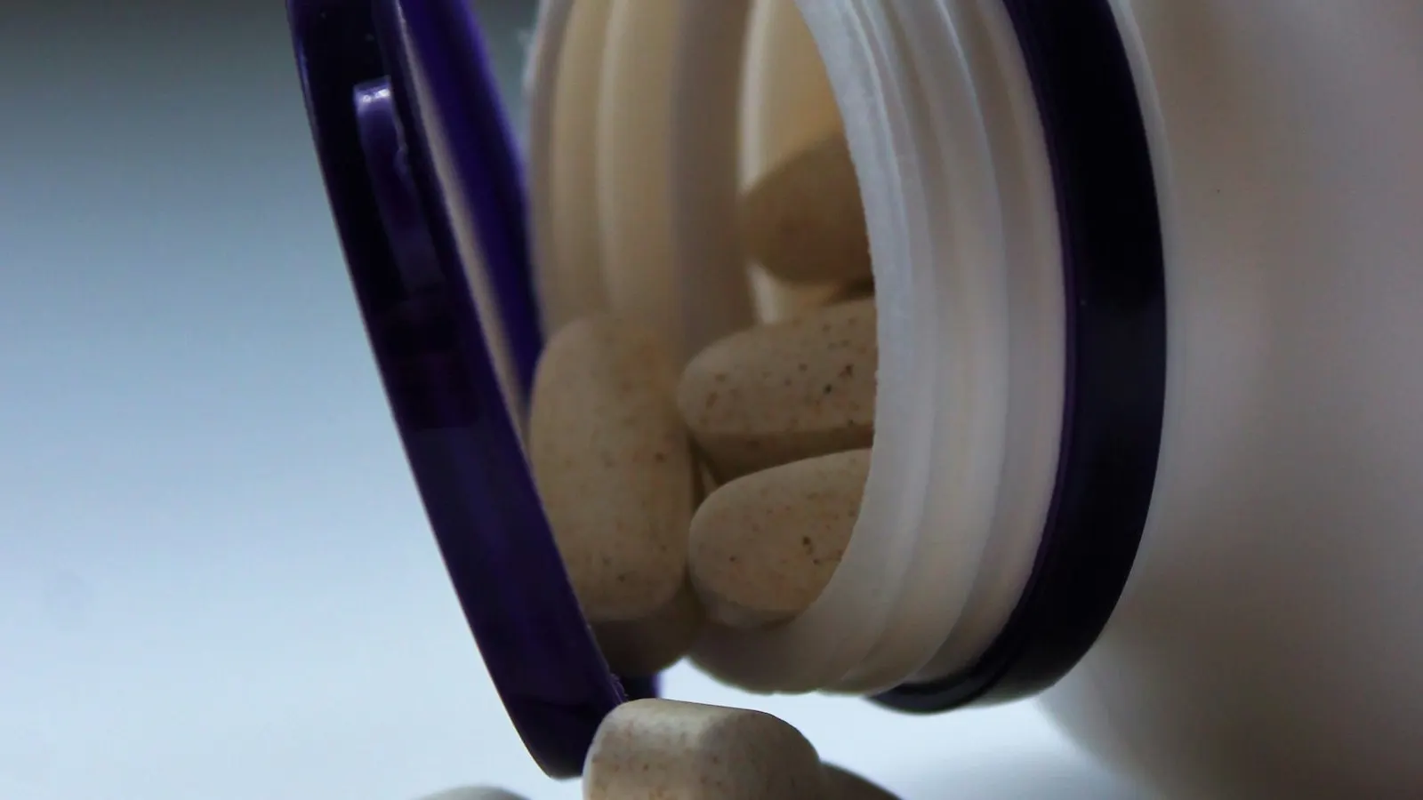 Supplement and vitamin bottles with screw caps, representing tamper-evident package decisions.