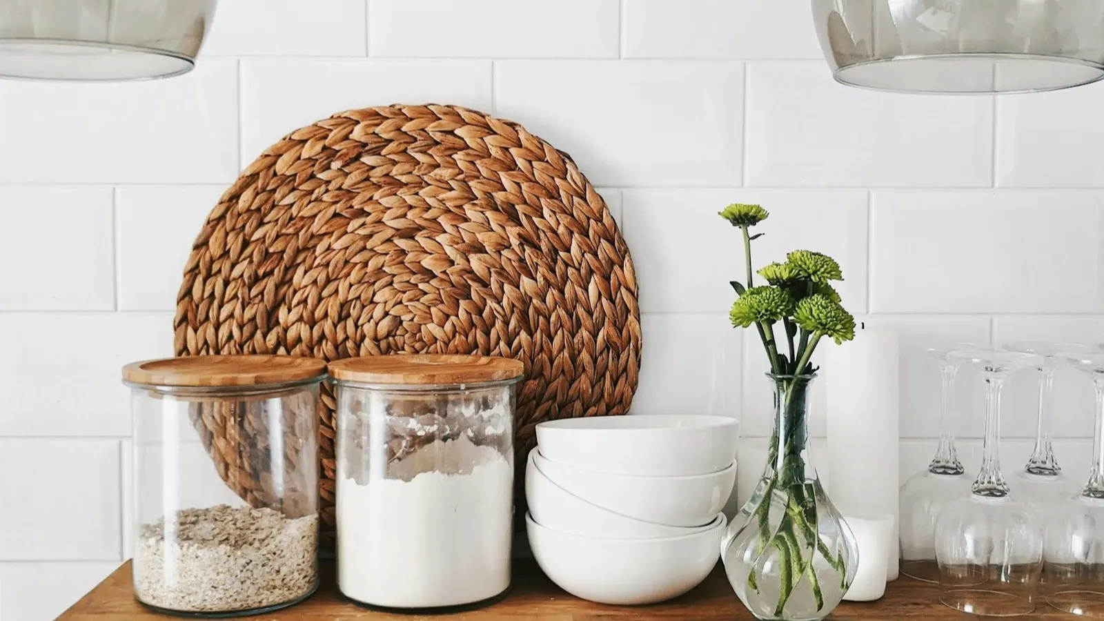 Glass jars of different sizes lined up on a shelf, illustrating the range of jar and Mason-jar closures a shrink band has to fit.