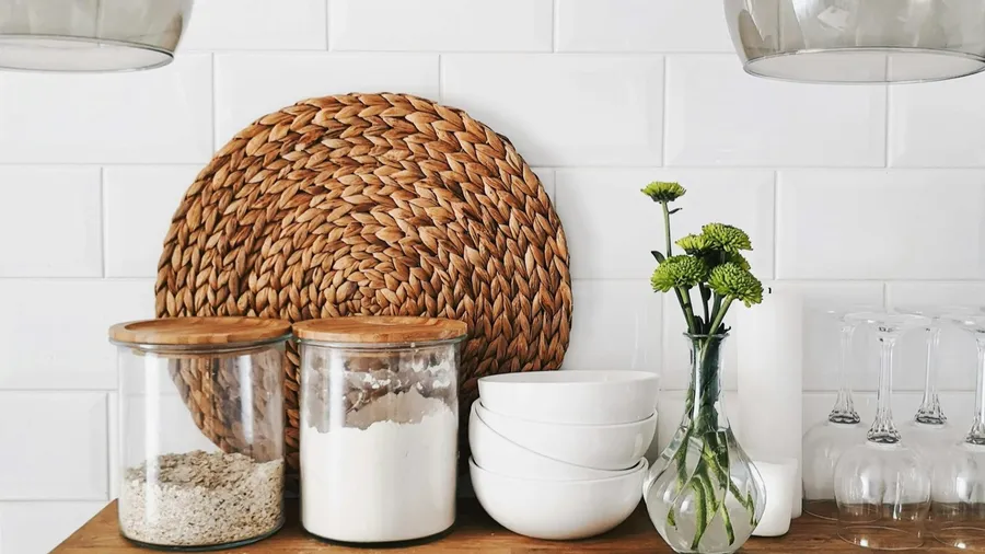 Glass jars of different sizes lined up on a shelf, illustrating the range of jar and Mason-jar closures a shrink band has to fit.